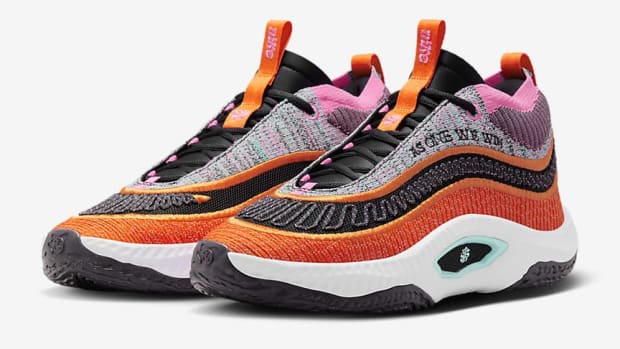 Side view of orange and black Nike shoes.